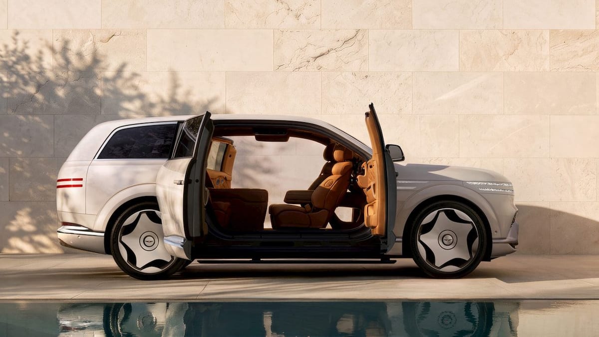 Vista del SUV eléctrico Genesis GV90 con sus puertas tipo coach abiertas mostrando el interior de lujo, exhibido en un evento de presentación