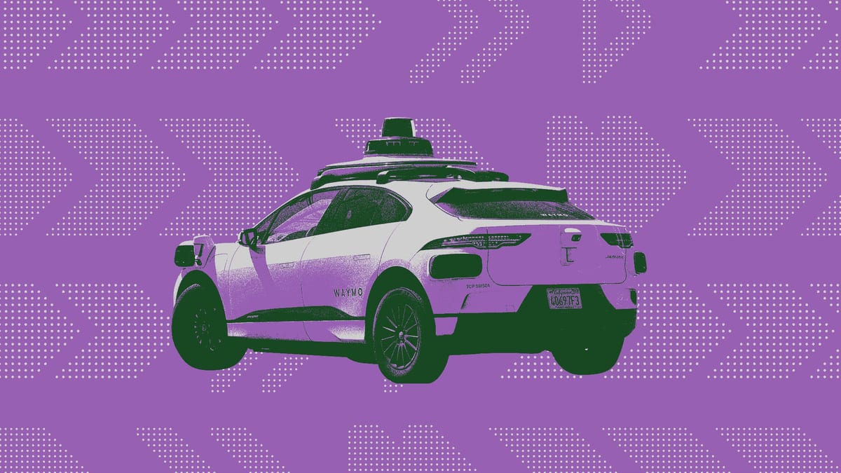 Un vehículo robotaxi de Waymo circulando por una calle, con el equipo de sensores, cámaras y lidar visible sobre el techo y los costados de la carrocería.